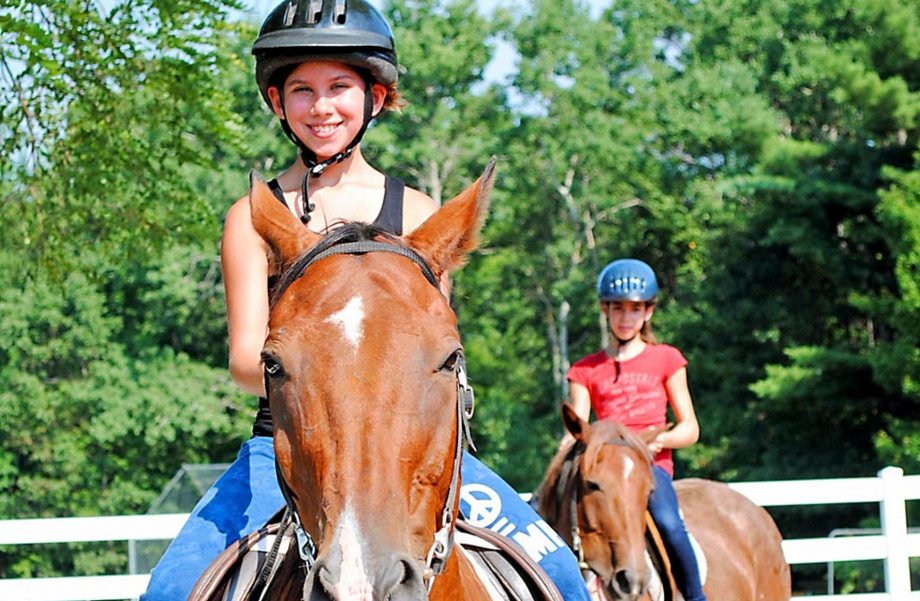 Girls horseback riding in ring