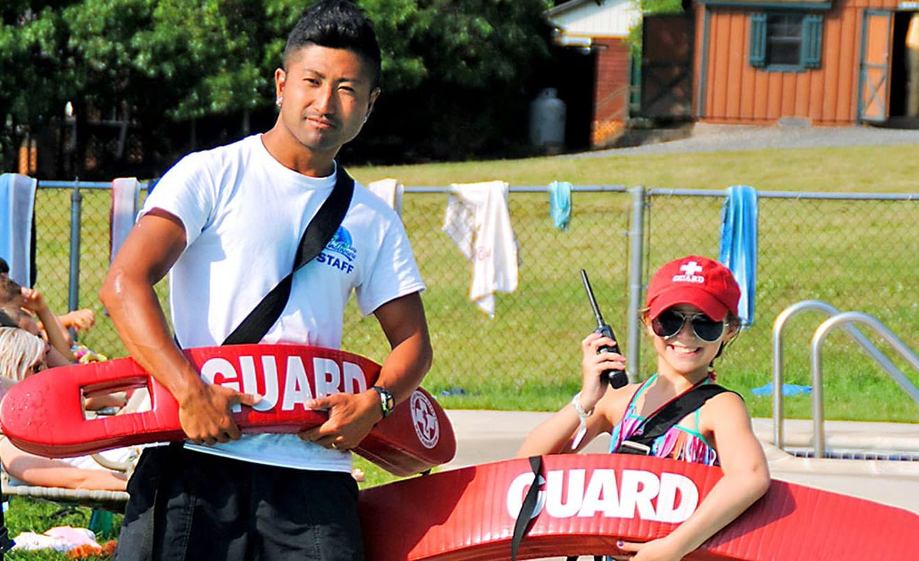 Staff and camper with lifeguard floatation devices