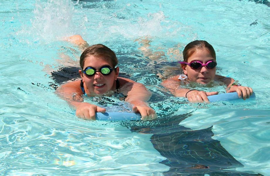 Girls on boogie boards in pool